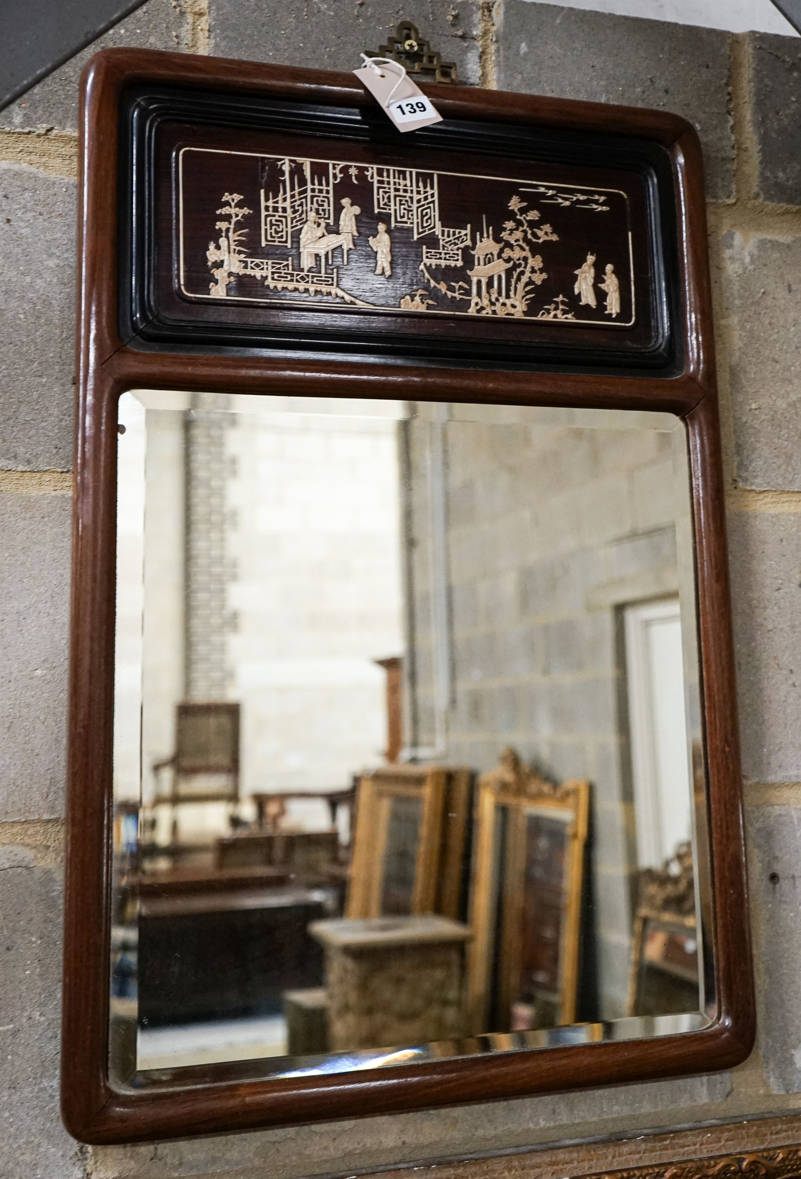 A Chinese hardwood wall mirror, with ivory inlaid panel of figures, balconies and pagodas, width 48cm, height 71cm H 72cm